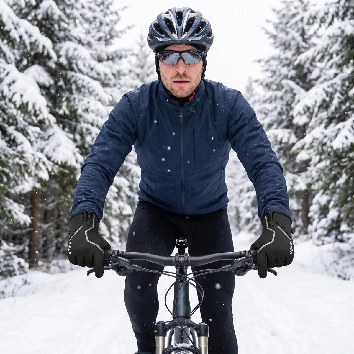 Radfahrer mit Vilico Handschuhen in Schwarz im verschneiten Wald